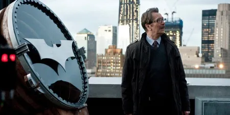 A frame from Christopher Nolan’s Batman movies of Commissioner Gordon standing on the rooftop preparing to light the batsignal.