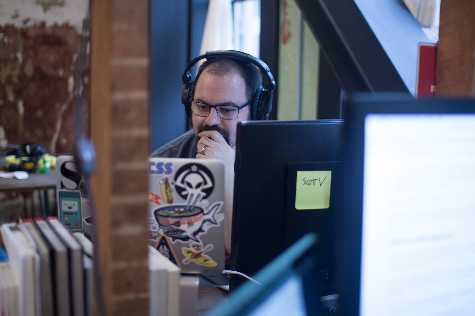 Scott at his desk, looking at his laptop, deep in thought.